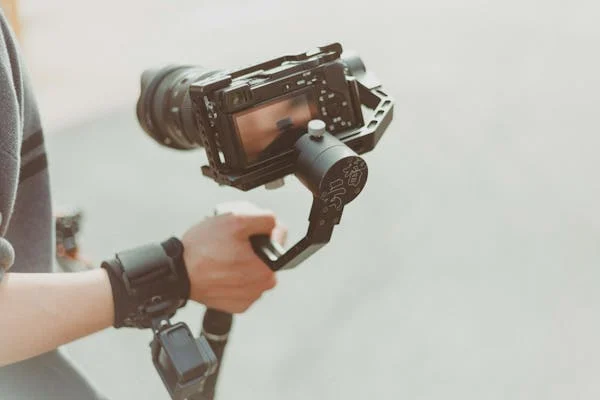 man holding a video camera recording for a brand's video marketing